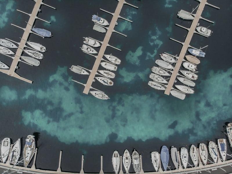 Boats moored in slips at a marina, seen from above